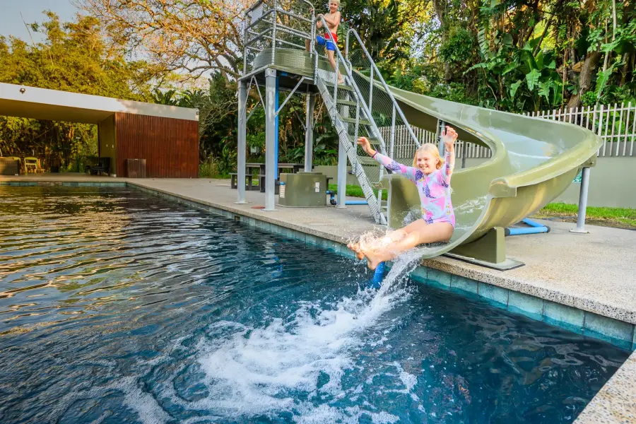 A child on the slide into the estate pool