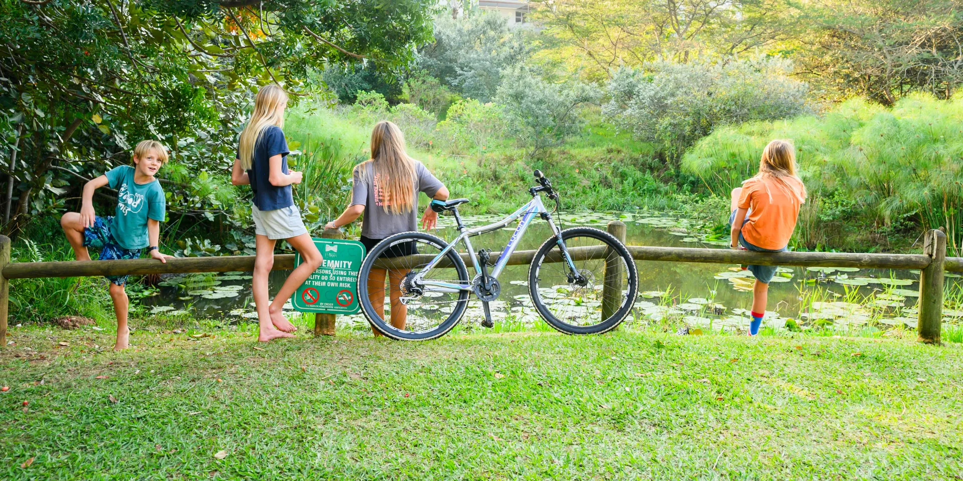 Four children and a bicycle at the lily-covered edge of one of the estate dams