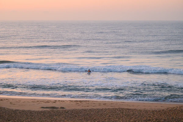 A swimmer in the surf off Salt Rock beach at first light