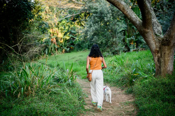 A resident walking her dog on a grassy trail through the estate