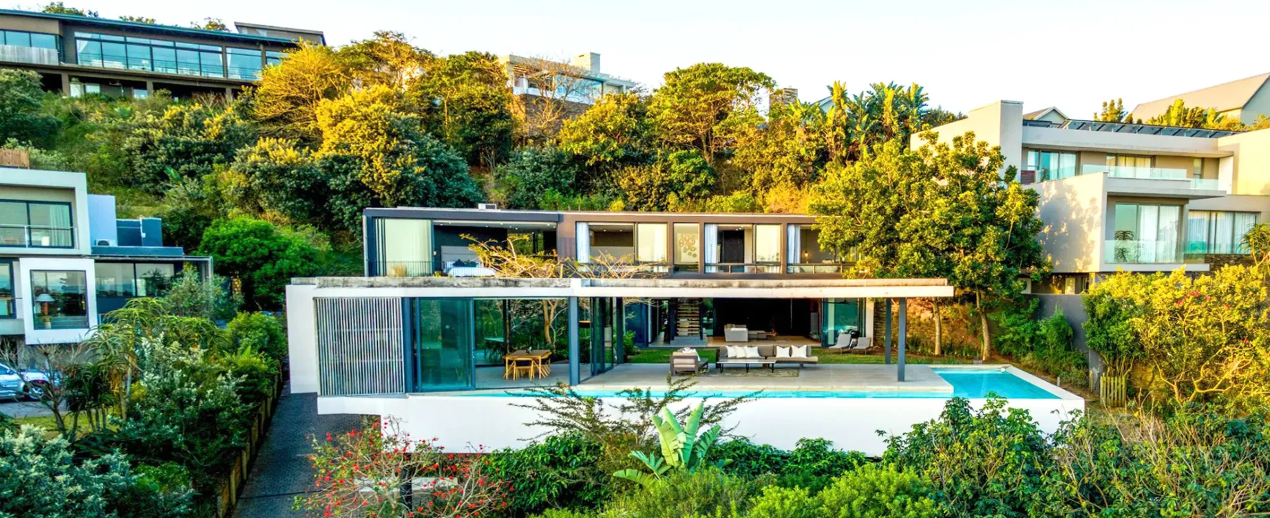 A bespoke home with a pool, set into the hillside among established trees