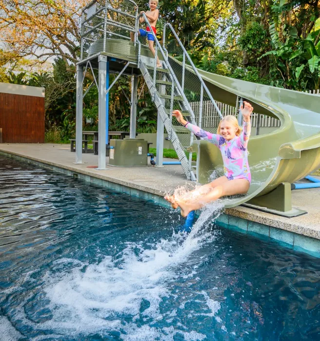 A child leaping off the slide into the pool at one of the play areas